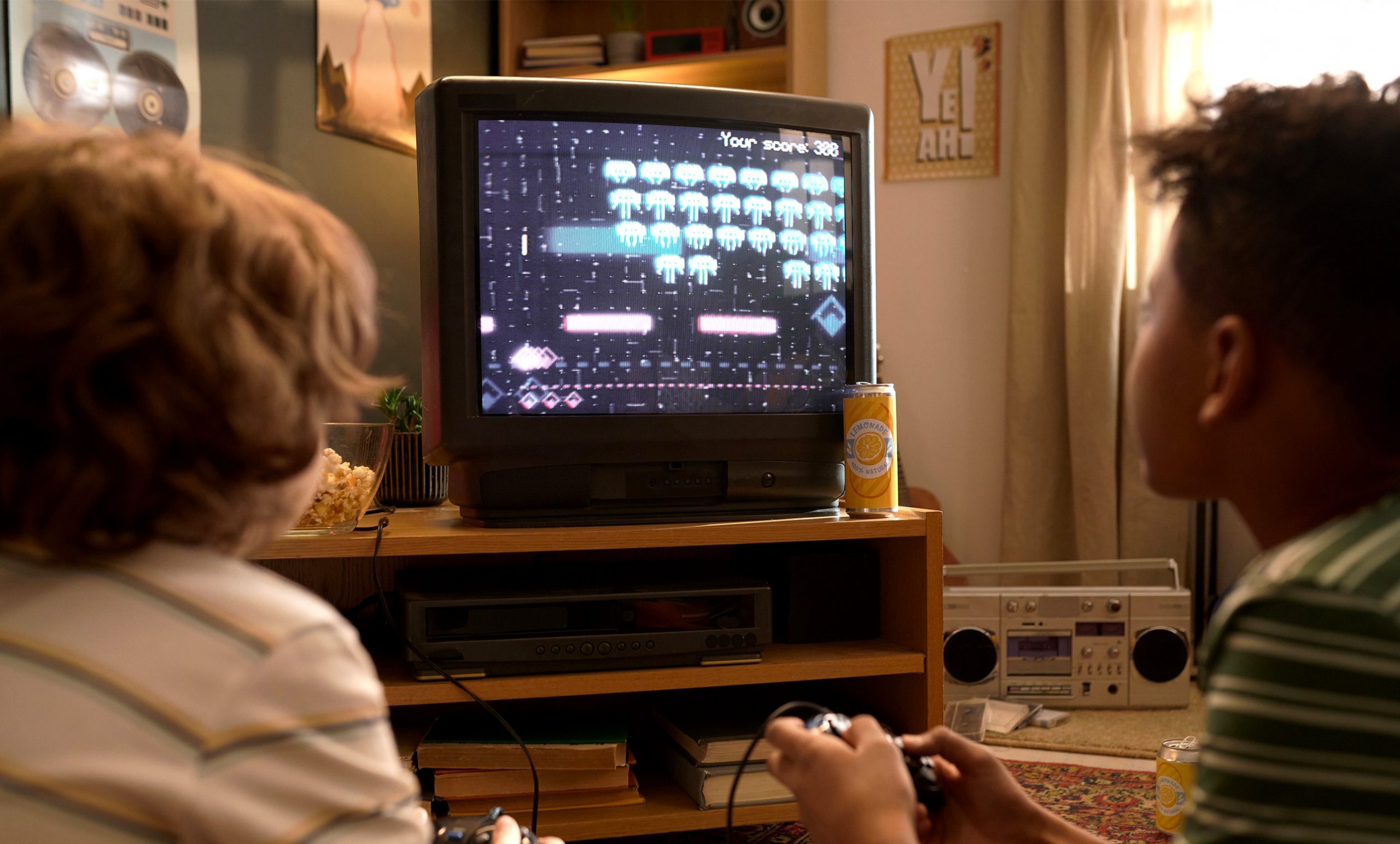 Two young children playing arcade-style games on an old television!