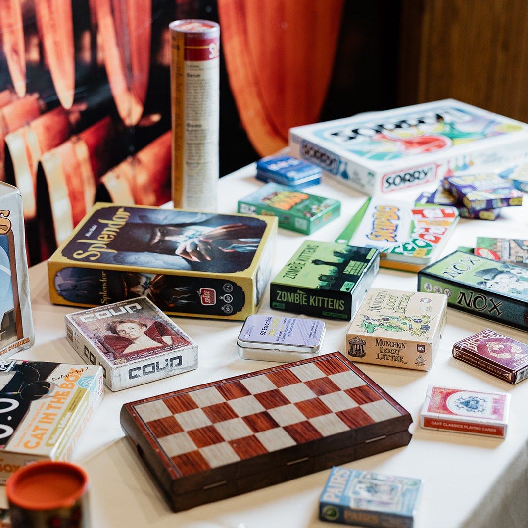 A number of different board games are left on a table for guests to play with at a wedding.