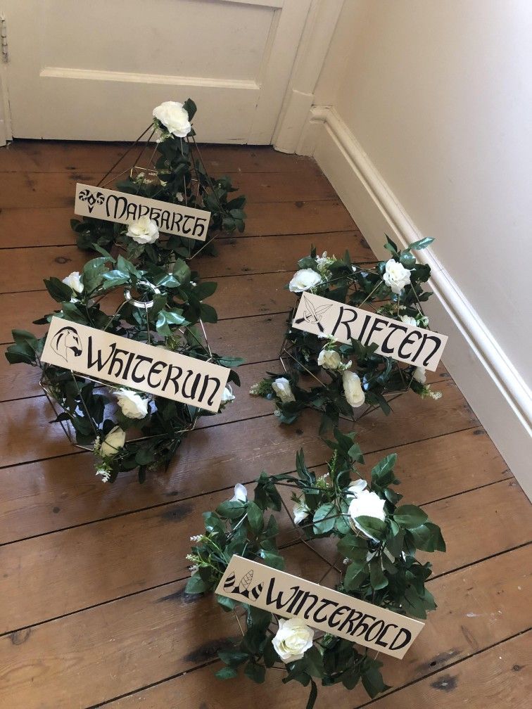 A set of wedding table centerpieces modeled after the Skyrim video game lying on a wooden floor.