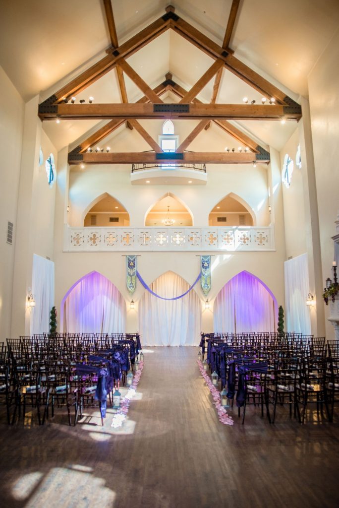 A currently empty wedding venue with inspiration taken from The Legend of Zelda for the color scheme. There are royal-looking banners hanging on the back wall.