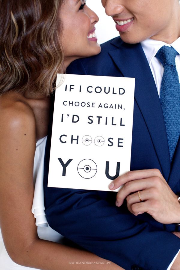 A bride and groom smile and look into each other's eyes while holding a Pokémon-themed card.