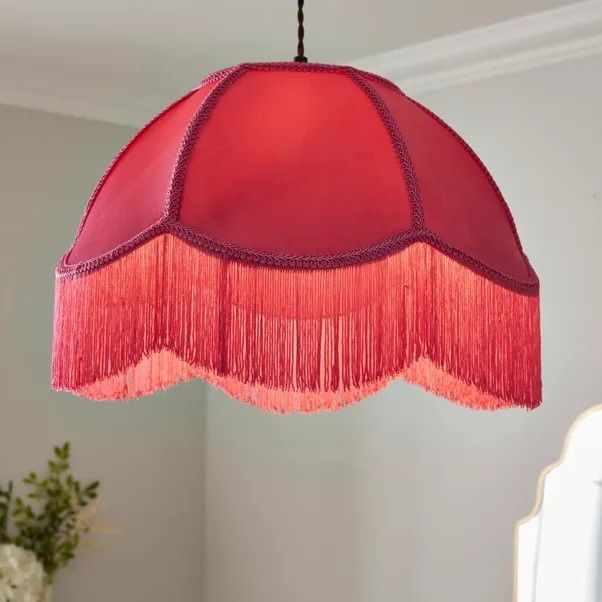 A pink fringed lampshade is shown hanging from the ceiling. 
