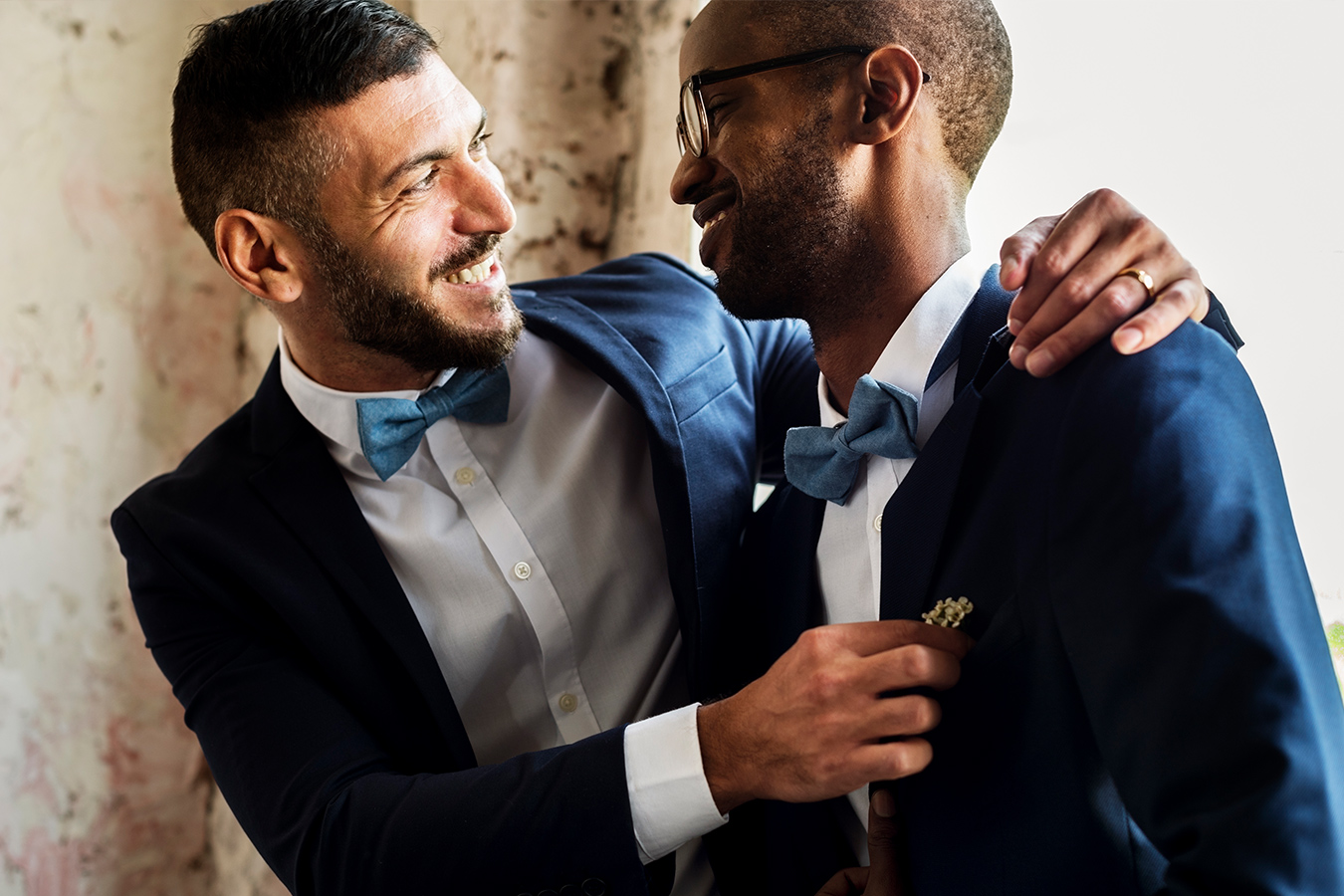 Newly married husbands are featured wearing matching dark blue/navy wedding suits.