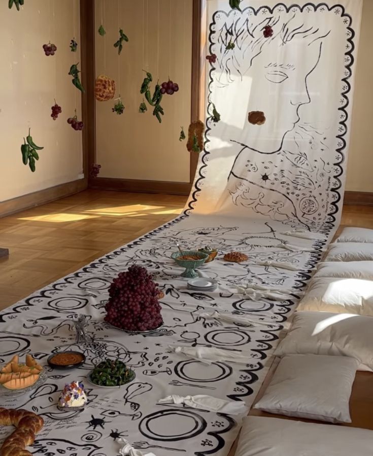 A painted canvas tablecloth that stretches up into a backdrop! There are little bowls and plates of food, spread out in a picnic style.
