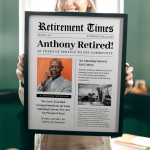 Person is holding a framed retirement newspaper-style poster.