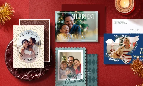 Various holiday cards from Zazzle are shown next to some tinsel and a lighting candle.